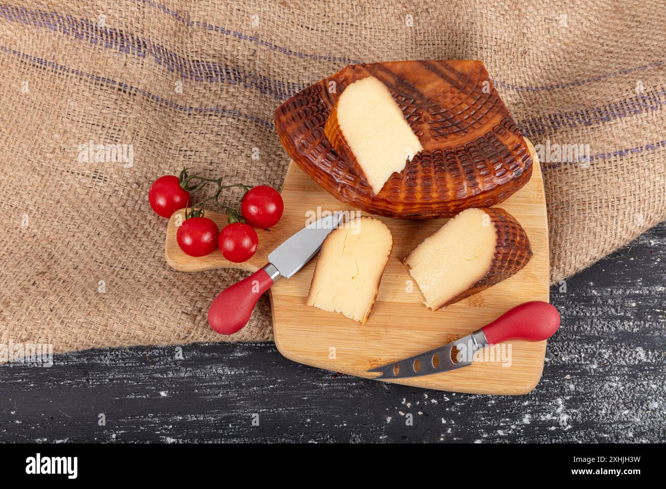 Geräucherter Käse. Geräucherter Tscherkessischer Käse. Geräucherter Tscherkessen-Käse auf einem Schneidebrett. Ortsname ; Abzug cerkez peyniri. Stockfoto