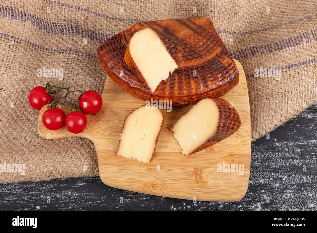 Geräucherter Käse. Geräucherter Tscherkessischer Käse. Geräucherter Tscherkessen-Käse auf einem Schneidebrett. Ortsname ; Abzug cerkez peyniri. Stockfoto