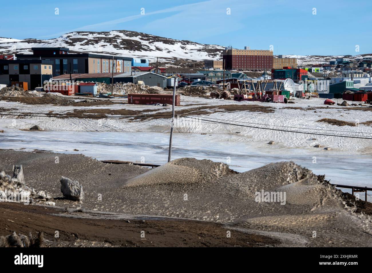 Riesiger schmutziger Schneehaufen auf dem Akilliq Drive in Iqaluit, Nunavut, Kanada Stockfoto