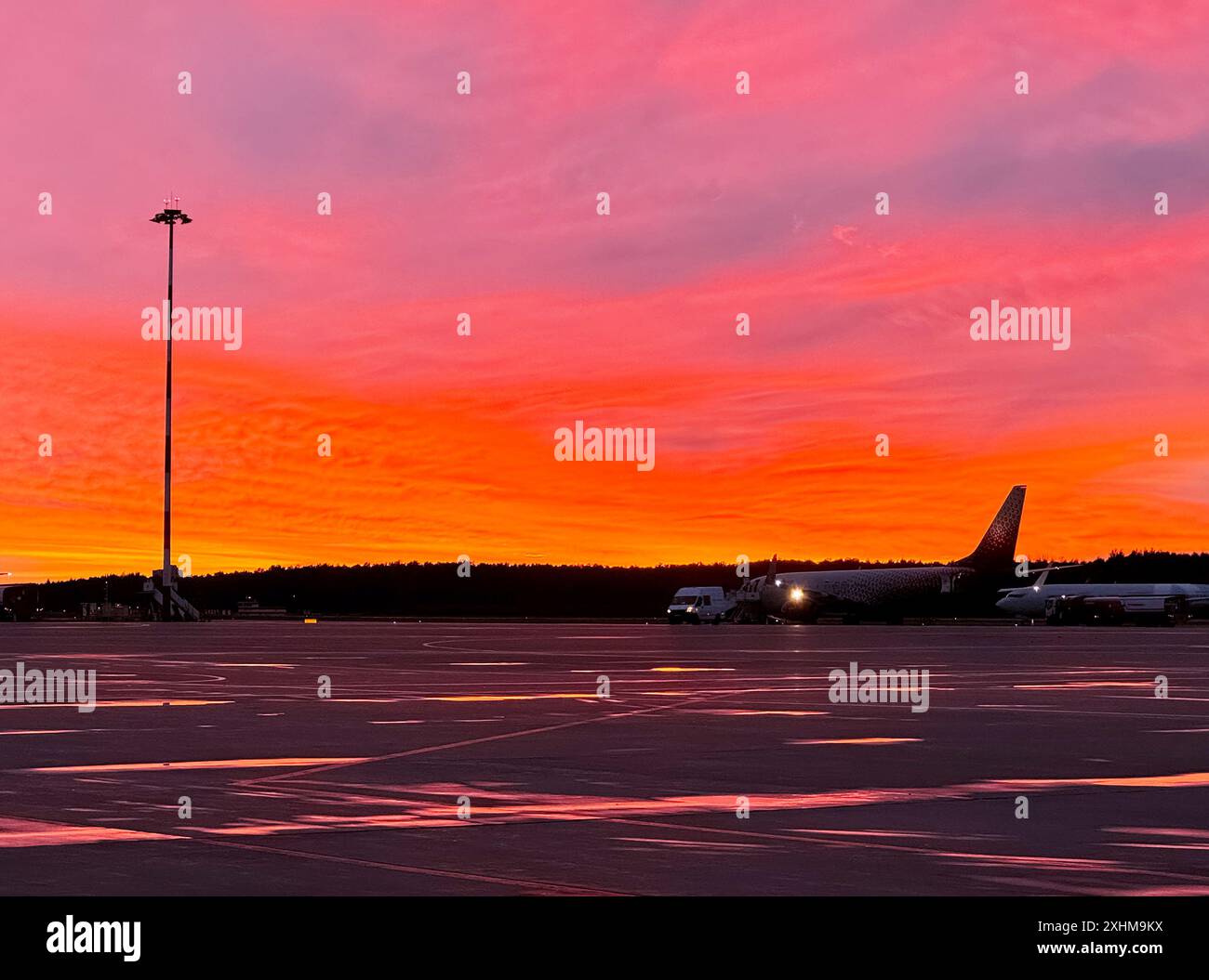 Sonnenuntergang am Flughafen. Flugplatzflugzeug bei Abendsonne. Stockfoto