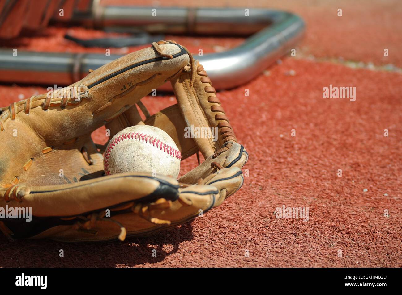 Ein alter Baseballhandschuh und Baseball liegen auf dem Rasen Stockfoto