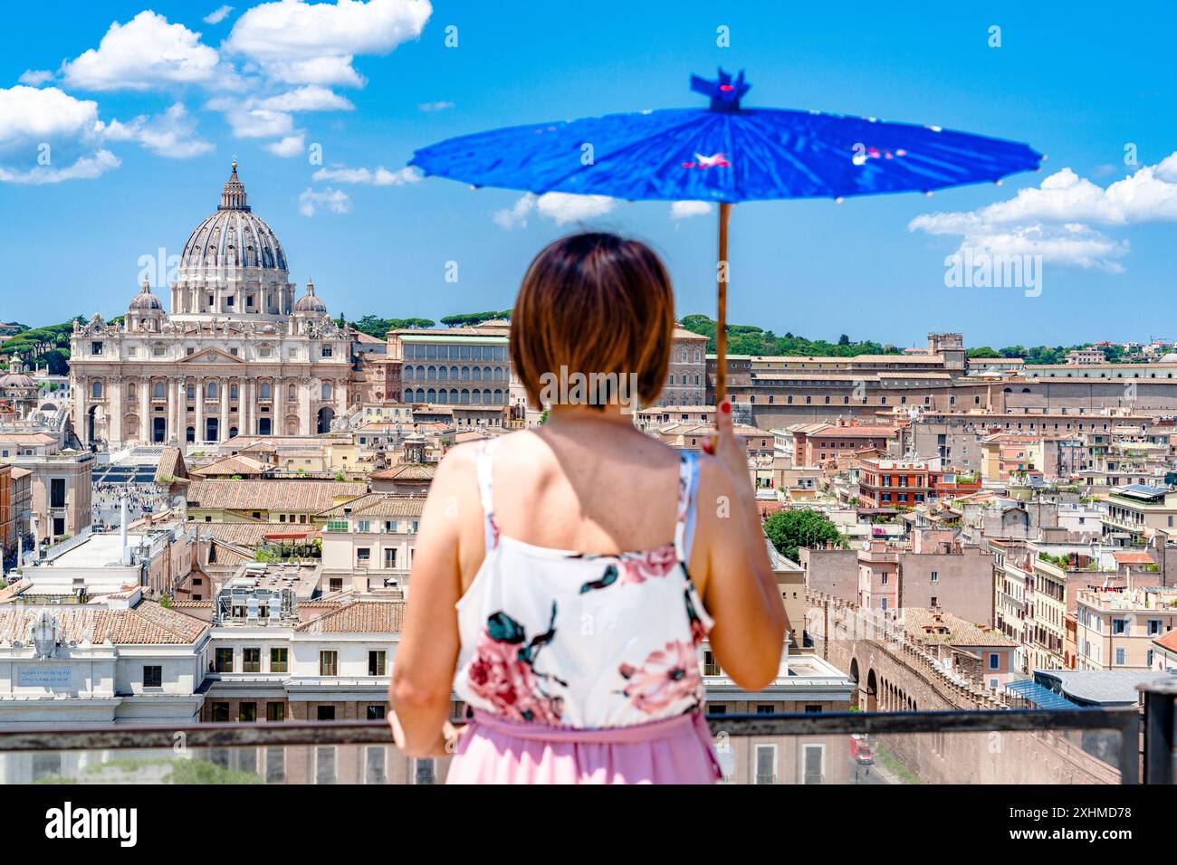 Frau mit Schirm, die von Castel Sant'Angelo aus auf den Vatikan schaut Stockfoto