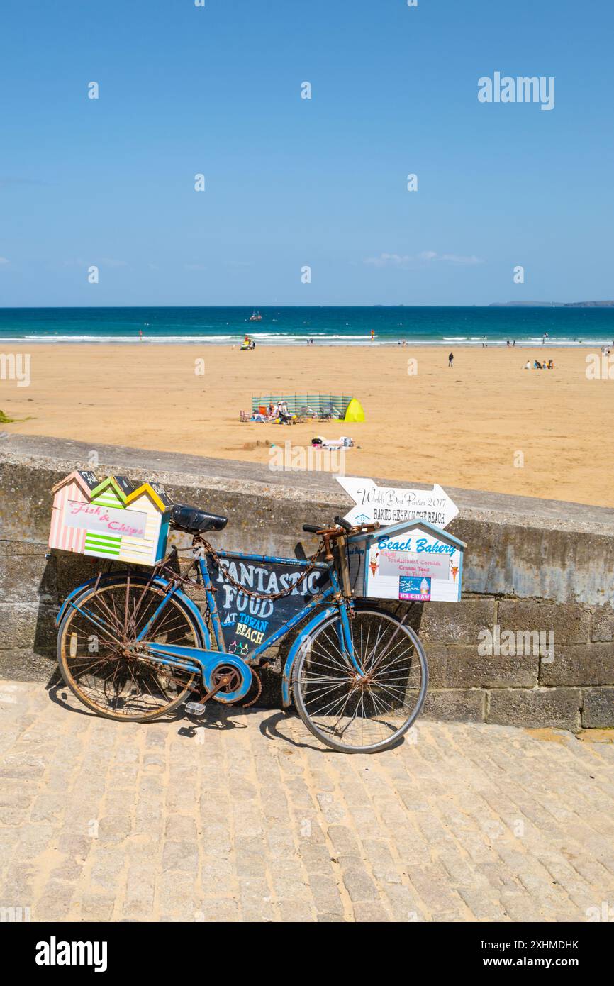 Ein altes Fahrrad wurde verwendet, um Lebensmittel am Towan Beach in Newquay in Cornwall in Großbritannien zu bewerben. Stockfoto
