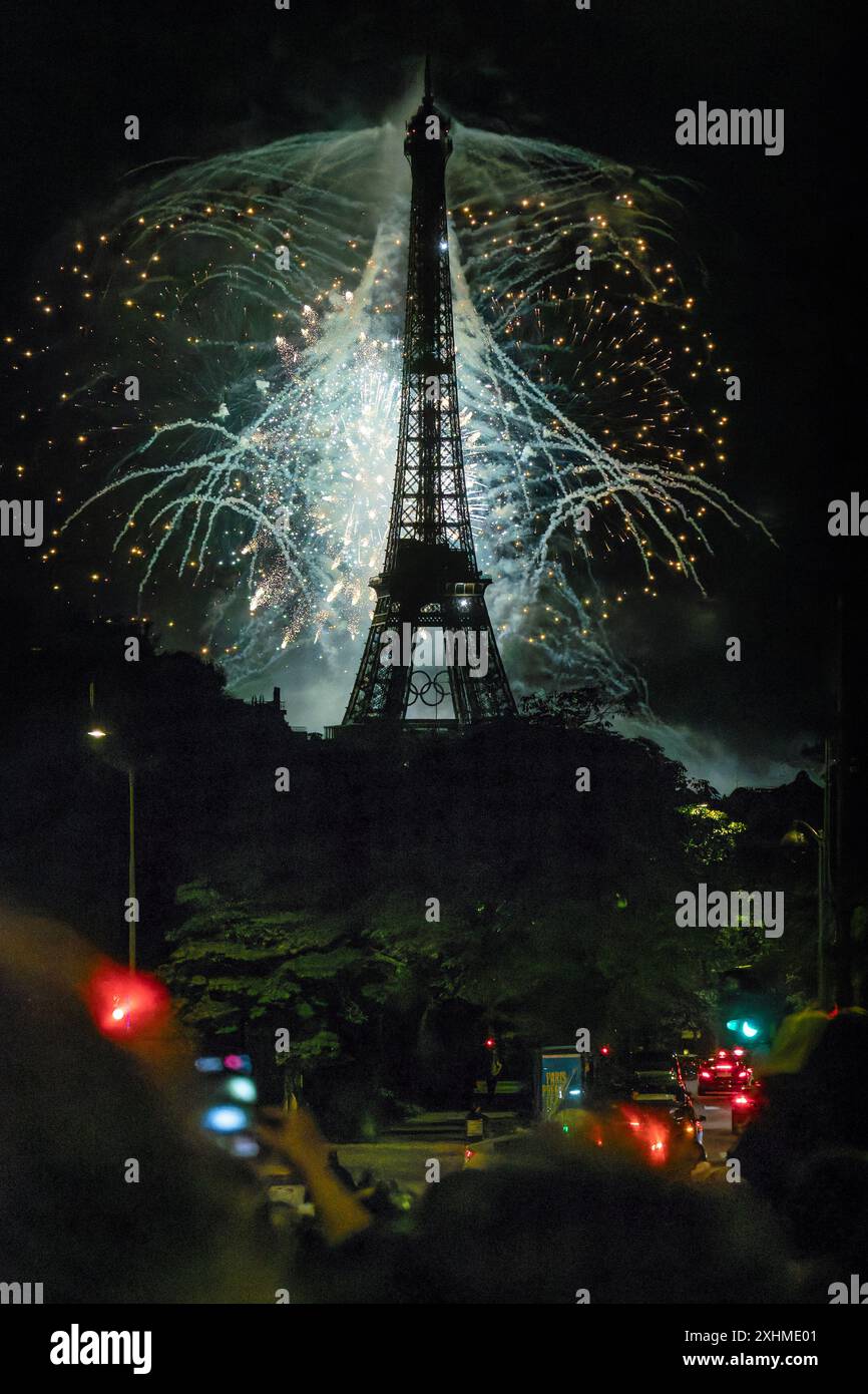 Paris, Frankreich, 14. Juli 2024. Riesiges Feuerwerk am Eiffelturm mit Menschen und Autos auf den Straßen Credit: Jacques Julien/Alamy Live News Stockfoto