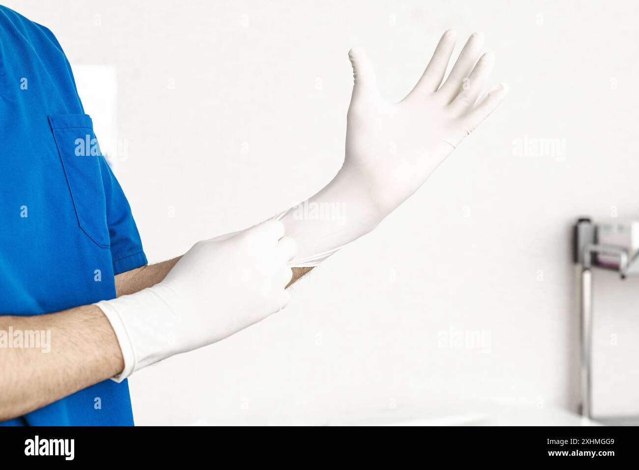 Mediziner in blauen Peelings mit sterilen Handschuhen, Vorbereitung auf einen klinischen Eingriff im Gesundheitswesen. Stockfoto