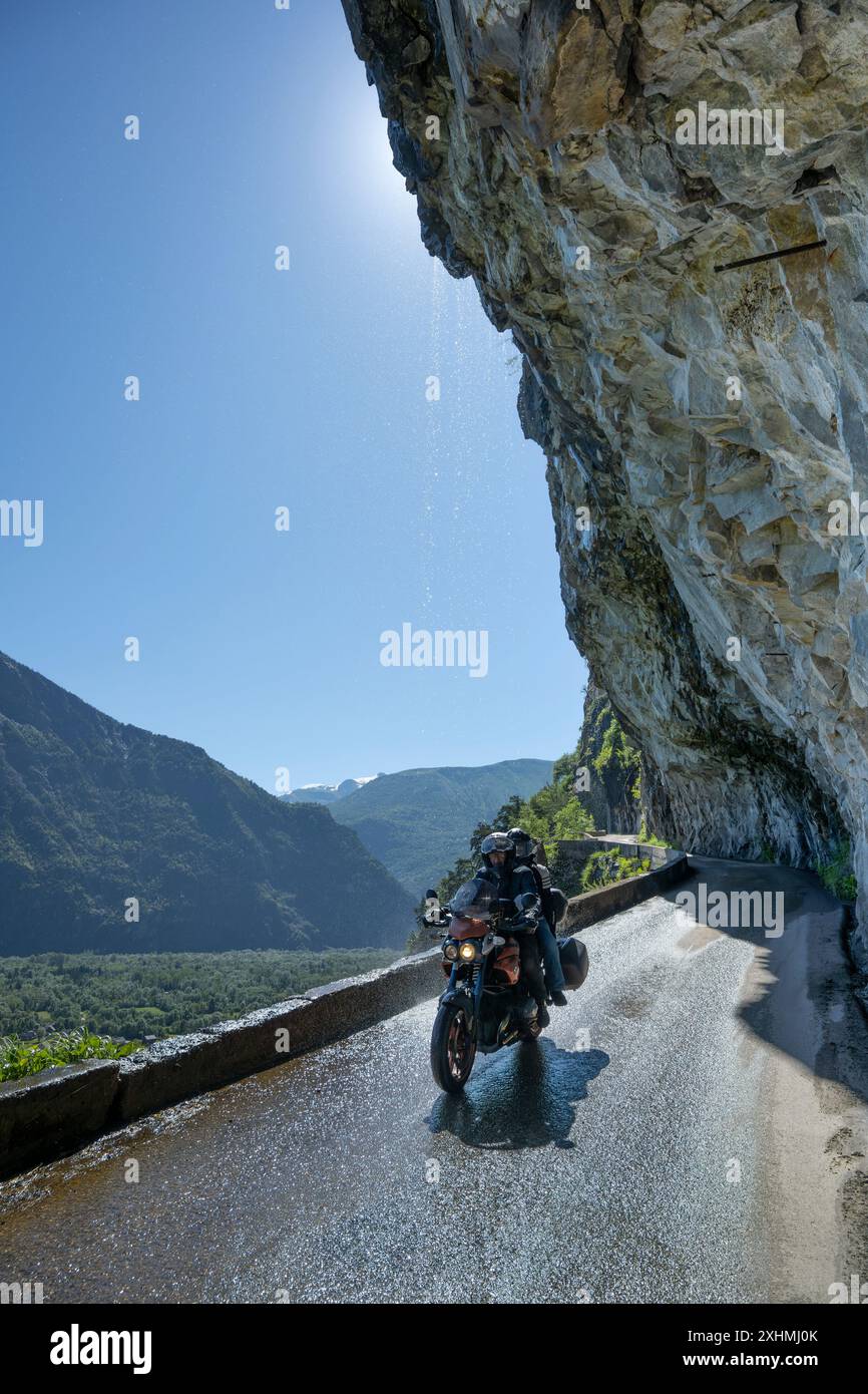 Ein Paar, das mit einem BMW Motorrad die Balkonstraße von Villard Notre Dame nach Bourg d'Oisans im Tal der französischen Alpen entlang fährt. Stockfoto