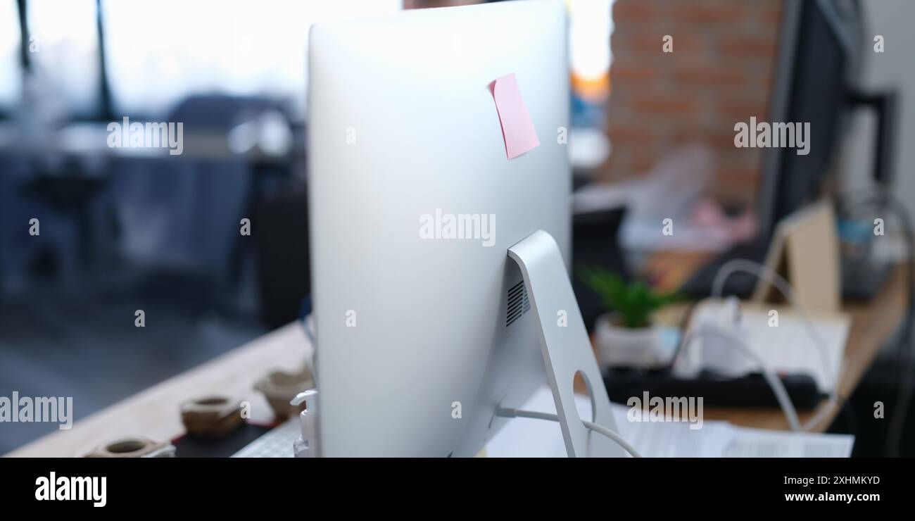 Nahaufnahme des Computermonitors mit Aufkleber im Büro. Modernes pc-Display mit Papiernotiz, Kopierraum. Digitales Gerät Stockfoto