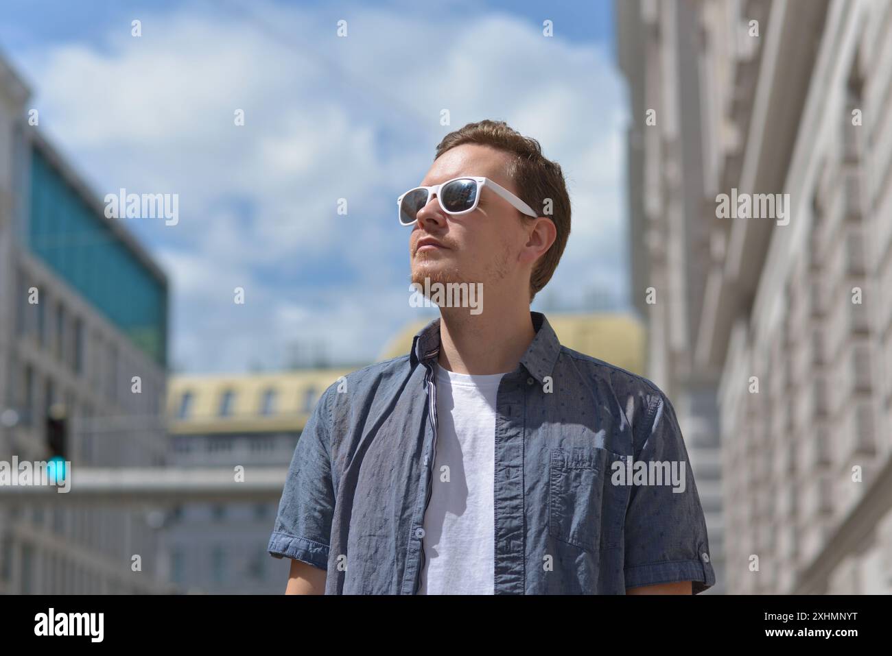 Ein Mann mit Sonnenbrille auf der Straße in Wien. Das Konzept des heißen, sonnigen Wetters in der Stadt. Ein Mann leidet unter der Hitze. Stockfoto
