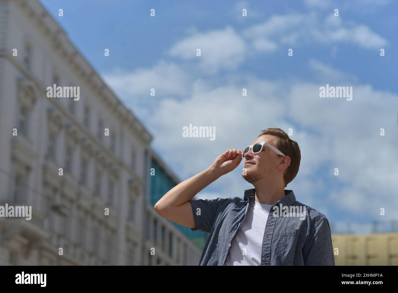 Ein Mann mit Sonnenbrille auf der Straße in Wien. Das Konzept des heißen, sonnigen Wetters in der Stadt. Ein Mann leidet unter der Hitze. Stockfoto