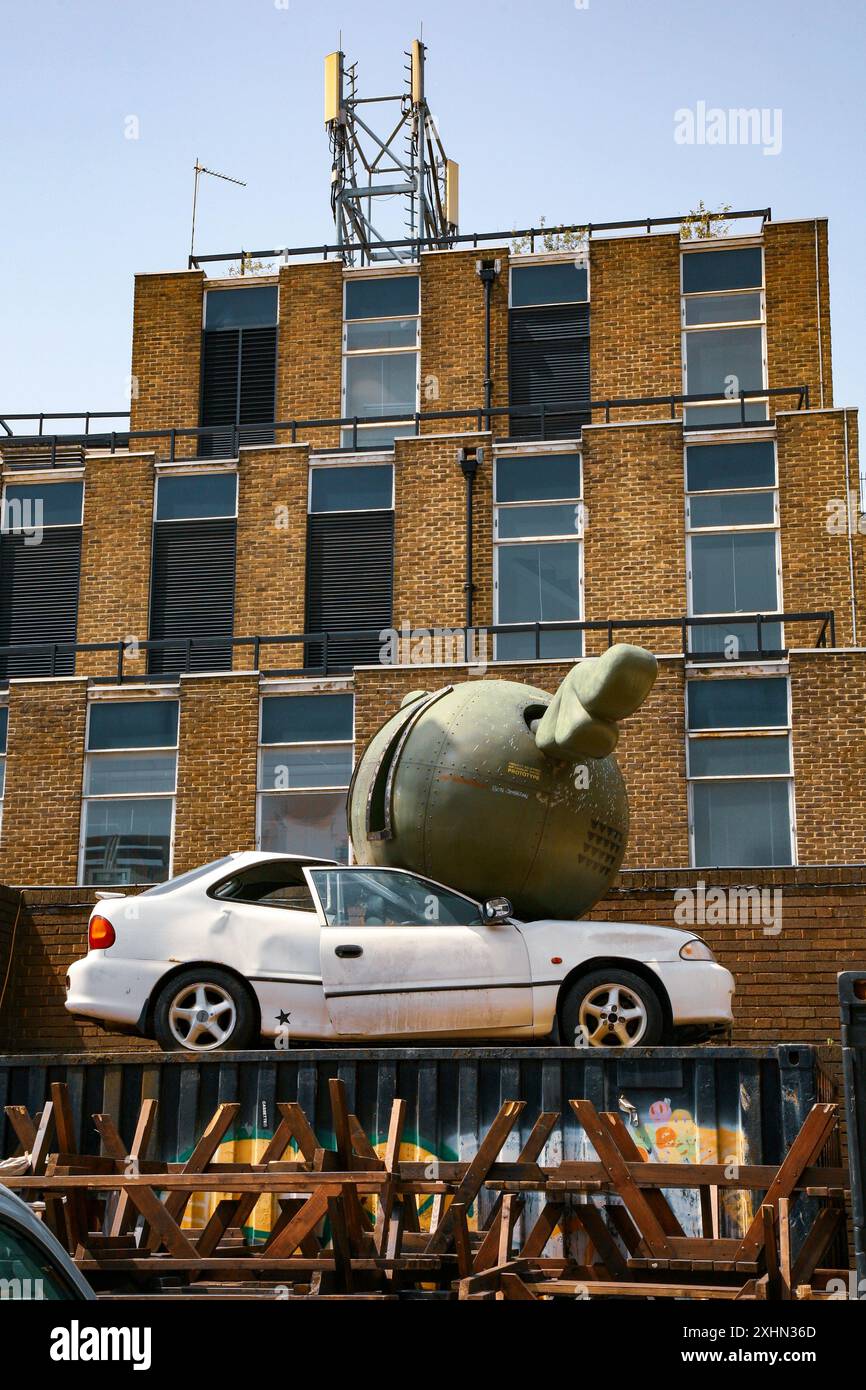 Auto zertrümmert durch grüne fliegende Bombe, Street Art Installation, Shoreditch vor der Brick Lane, East London, Großbritannien Stockfoto