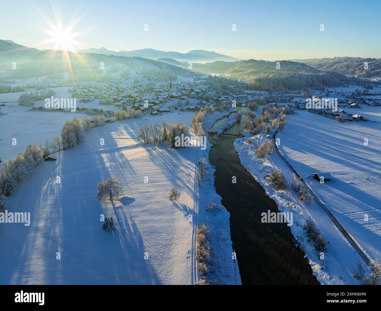 Luftaufnahme eines Flusses und Dorfes vor den Bergen, Winter, Abendlicht, Schlehdorf, Loisach, Blick nach Großweil, Bayern, Deutschland, Europa Stockfoto