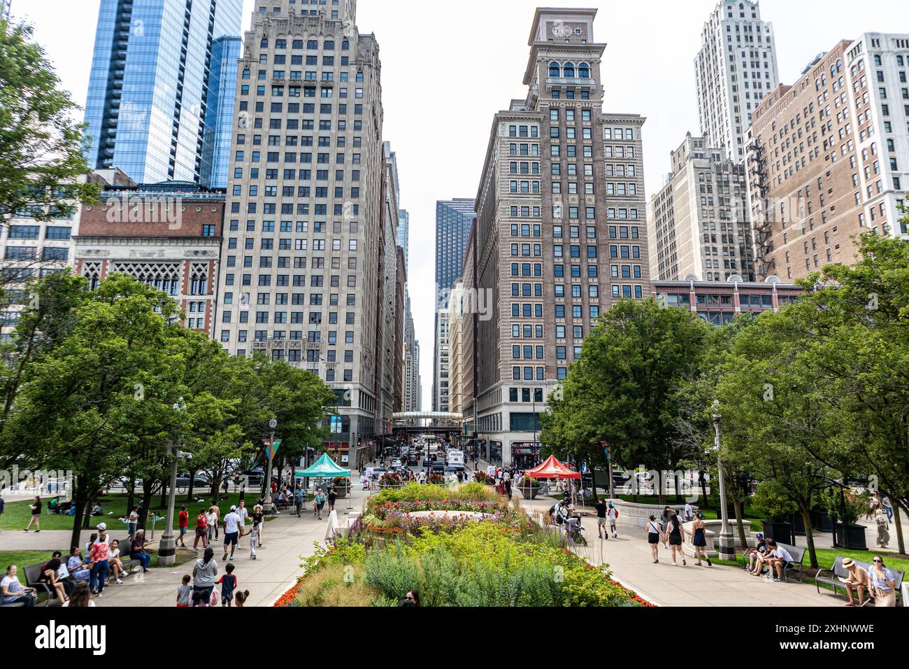 Touristenmassen im Chicagos Millennium Park mit Blick auf die E Madison Street Stockfoto