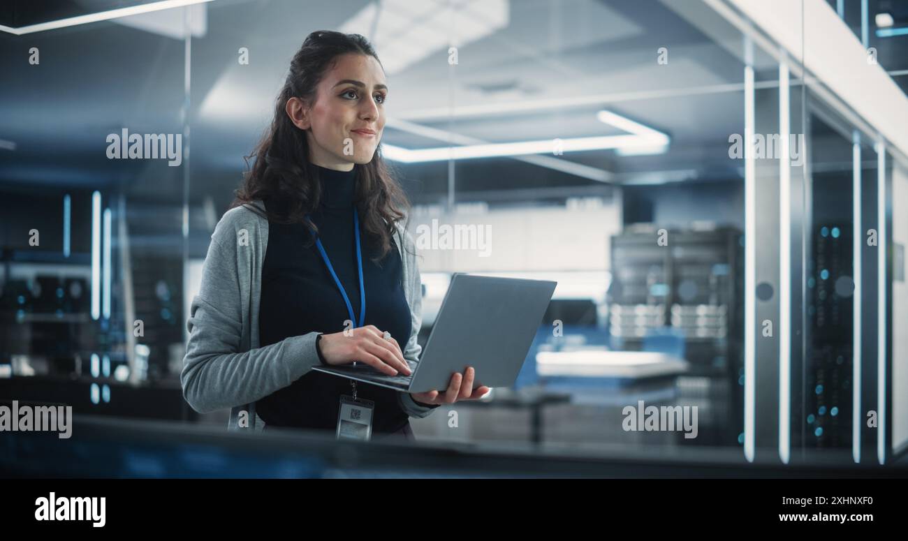 Porträt einer schönen glücklichen Frau, die einen Laptop benutzt, sich im Büro umsieht, denkt und Probleme löst. IT-Spezialist, Software-Engineer oder Entwickler Stockfoto