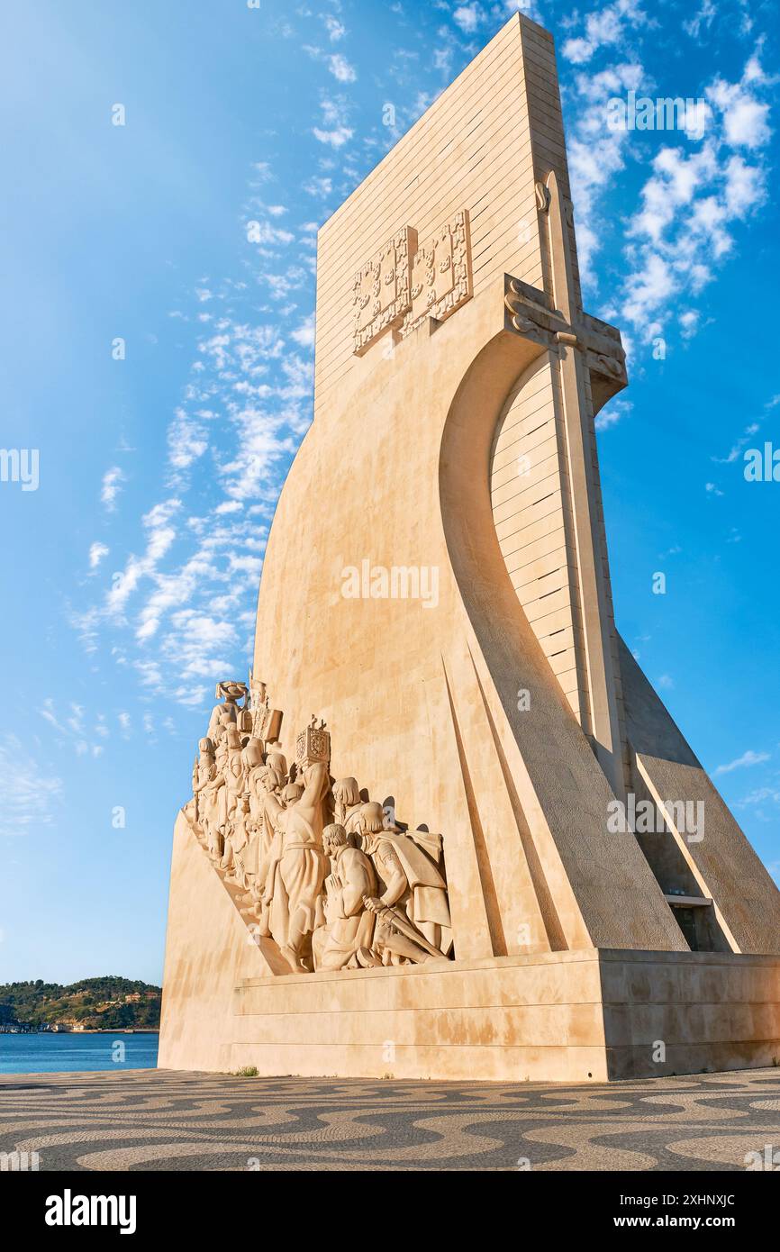 Monument to Discoveries oder Padrao dos Descobrimentos to Age of Discovery geformt wie Schiff und Schwert mit Statuen von Prinz Heinrich dem Seefahrer und großen Menschen der portugiesischen Seeleute Geschichte, Lissabon, Portugal, am klaren blauen Himmel und Sonnenstrahlen am Tag Stockfoto
