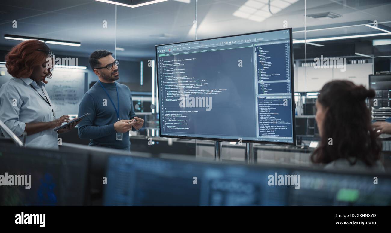 Gruppe multiethnischer Softwareentwickler, die eine Besprechung zur Überprüfung des Kodex durch die Abteilung für Computertechnik durchführen. Spezialisten, die neue Ideen entwickeln und Probleme im Büro lösen Stockfoto