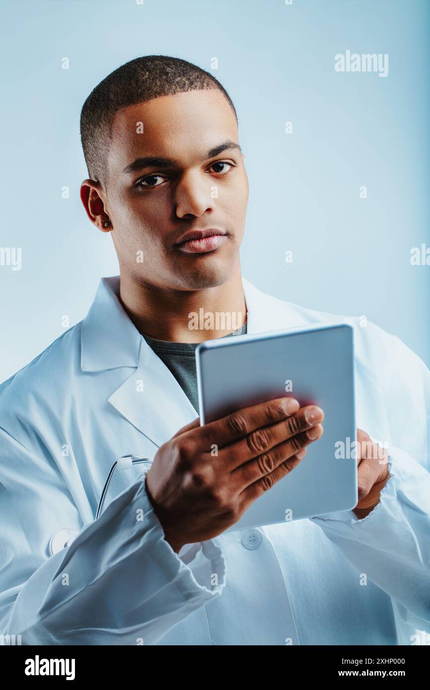 Einzelperson in einem weißen Laborkittel, der ein Tablet mit einem fokussierten Look hält. Er ist ein Datenwissenschaftler, der sich für Deep Learning, LLMS, Data Science und Big D engagiert Stockfoto