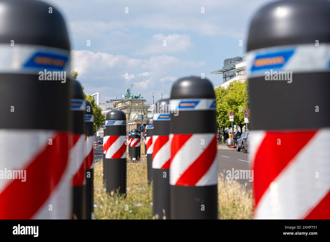 Es gibt eine Reihe rot-weiß gestreifter Barrieren auf der Straße. Im Hintergrund ist das Brandenburger Tor zu sehen. Stockfoto