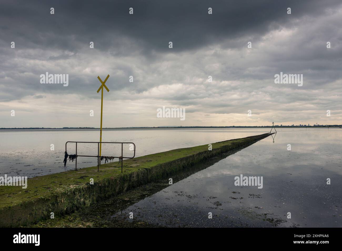 Auslaufleitung in Langstone Harbour, Hampshire, Großbritannien. Dramatischer Himmel Stockfoto