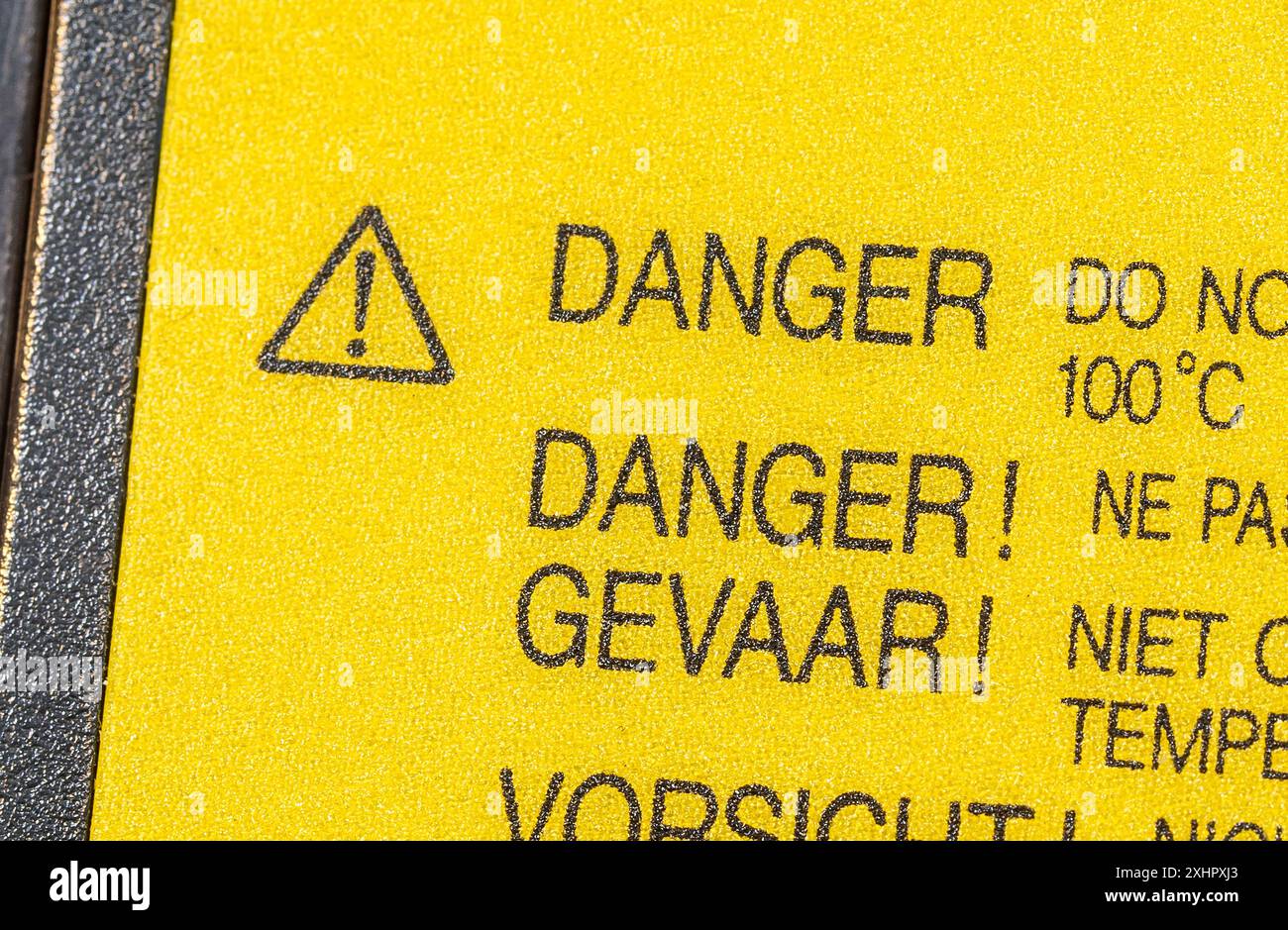 Hellgelbes Gefahrenetikett mit einem Ausrufezeichen in einem Dreieck auf einem Lithium-Ionen-Laptop-Li-Ionen-Akku, Stockfoto