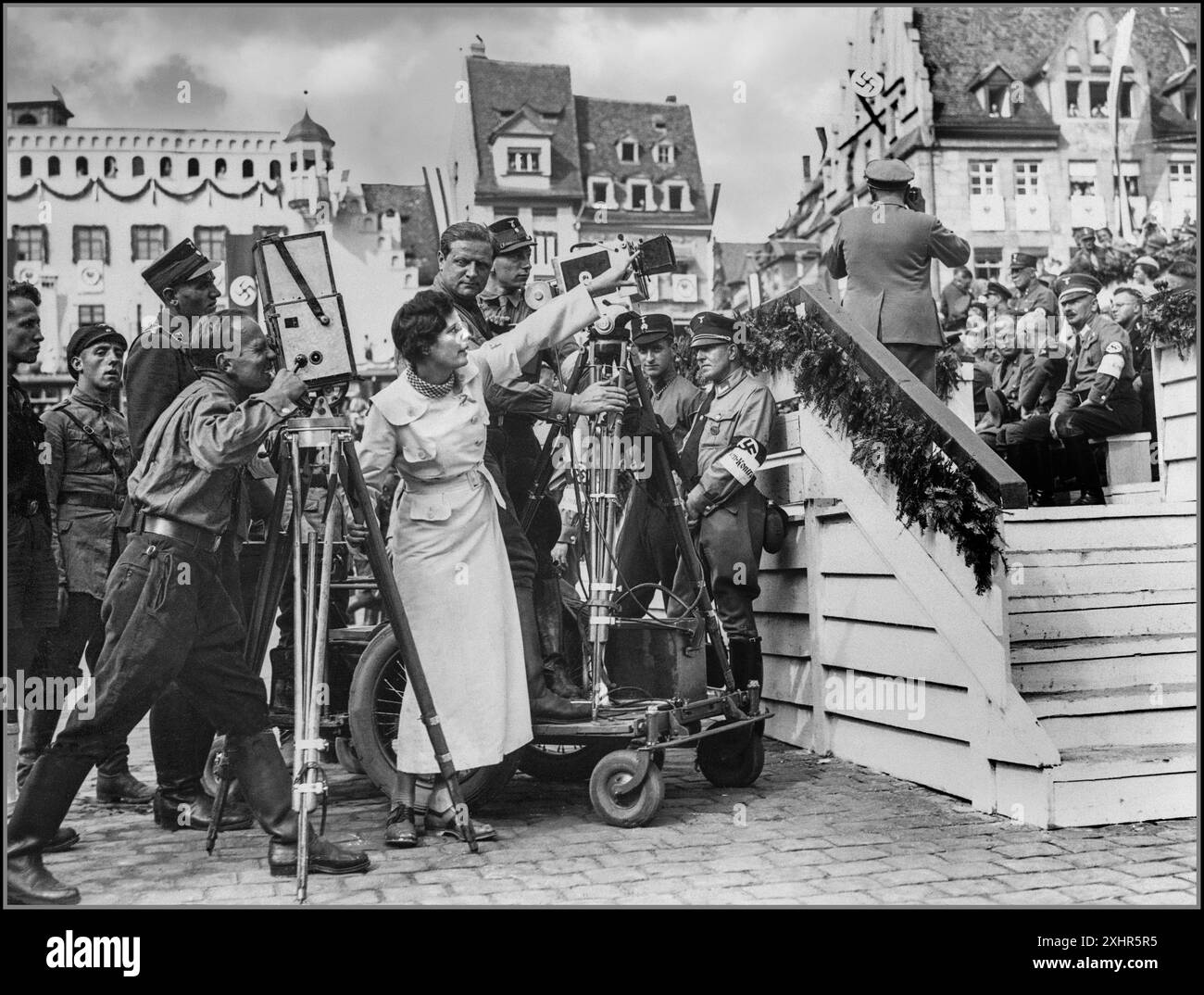 LENI RIEFENSTAHL der deutsche NS-Propagandameister Leni Riefenstahl (1902–2003) während der Dreharbeiten zum Film Triumph des Willens 1934 vor Ort in Nürnberg. Hinter ihrem Chefkameramann Sepp Allgeier (1895–1968) hört sie zu. Umgeben von der Sturmabteilung (SA) der NSDAP paramilitärischen Armee Stockfoto