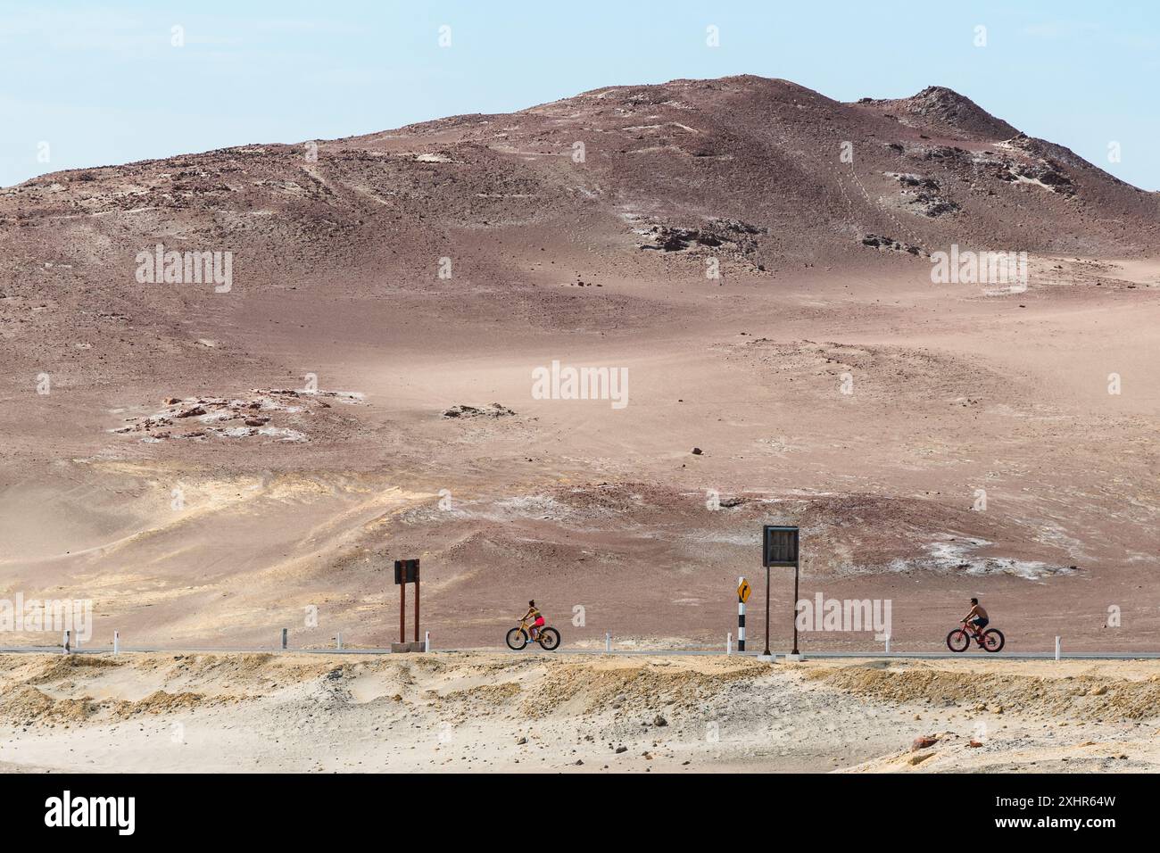 Paracas, Peru - 18. März 2019: Radfahrer erkunden Wüstenstraßen in steilen Hügeln. Stockfoto