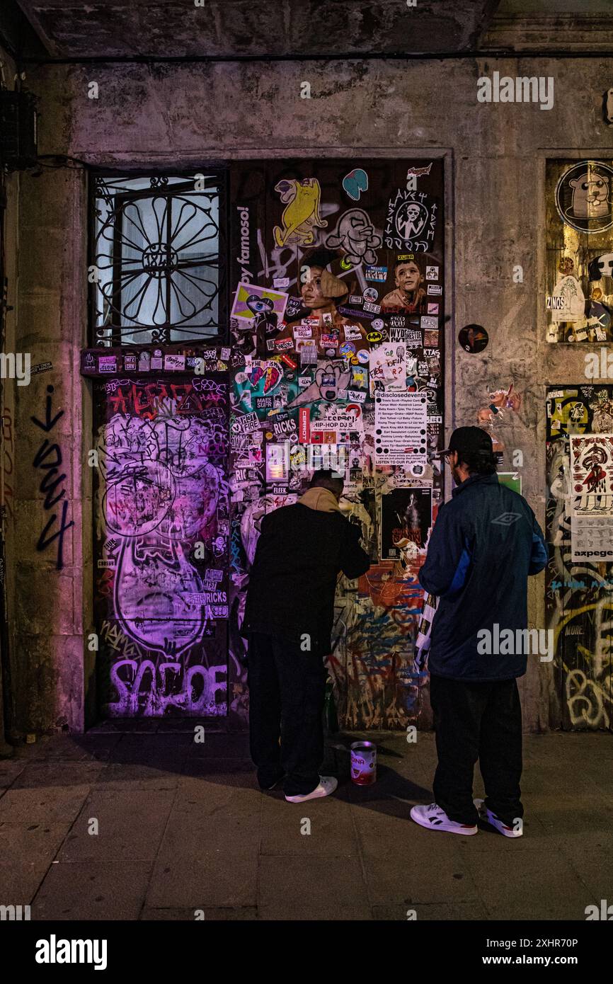 Zwei Menschen fliegen mit Plakaten auf einer Graffiti-Wand in einem künstlerischen Street Art-Bild Stockfoto