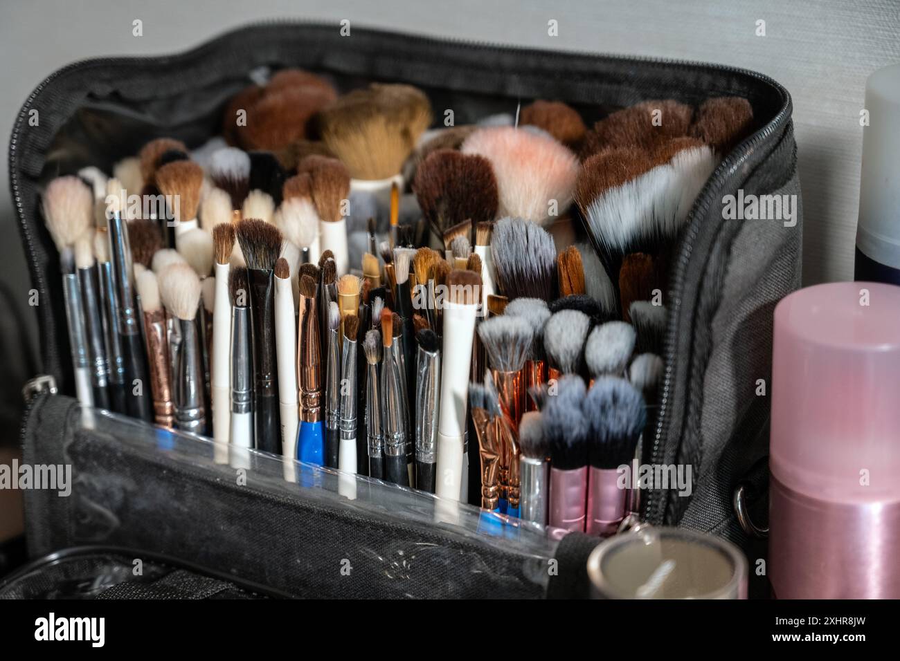 Verschiedene Kosmetikbürsten in organisierter Reißverschlusstasche, damit Make-up-Künstler das Produkt auf jeden Teil des Gesichts der Schönheit auftragen können. Stockfoto