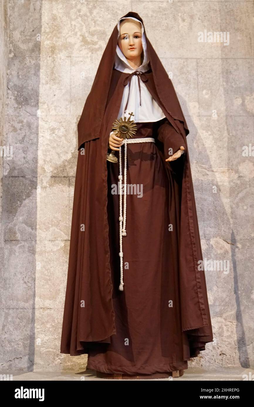 Havanna: Eine der ältesten Kirchen Kubas auf der Plaza de la Catedral, Kathedrale von San Cristobal, Statue einer Nonne in braunem Gewand, die eine Ordensfrau hält Stockfoto