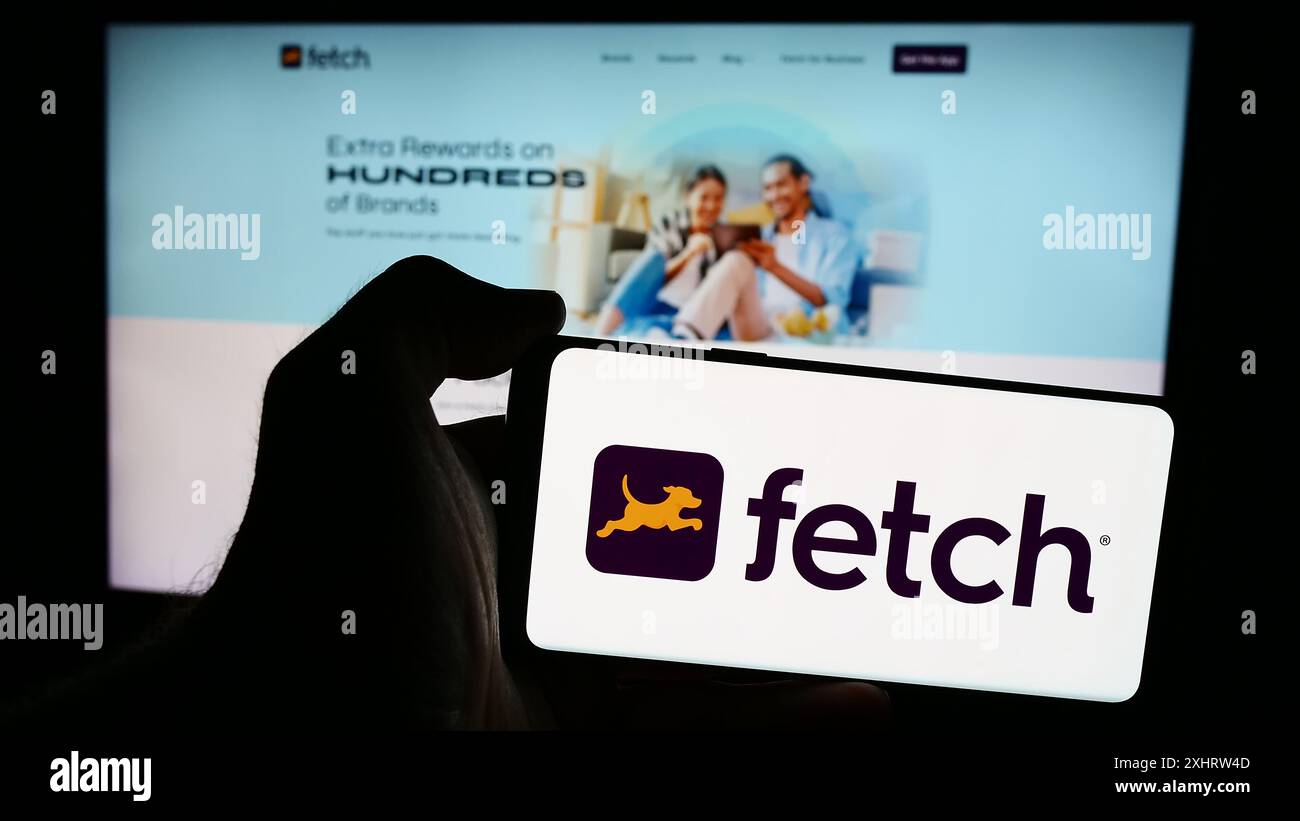 Person, die ein Smartphone mit dem Logo des US-amerikanischen Reward App-Unternehmens Fetch Rewards LLC vor der Website hält. Schwerpunkt auf dem Display des Telefons. Stockfoto