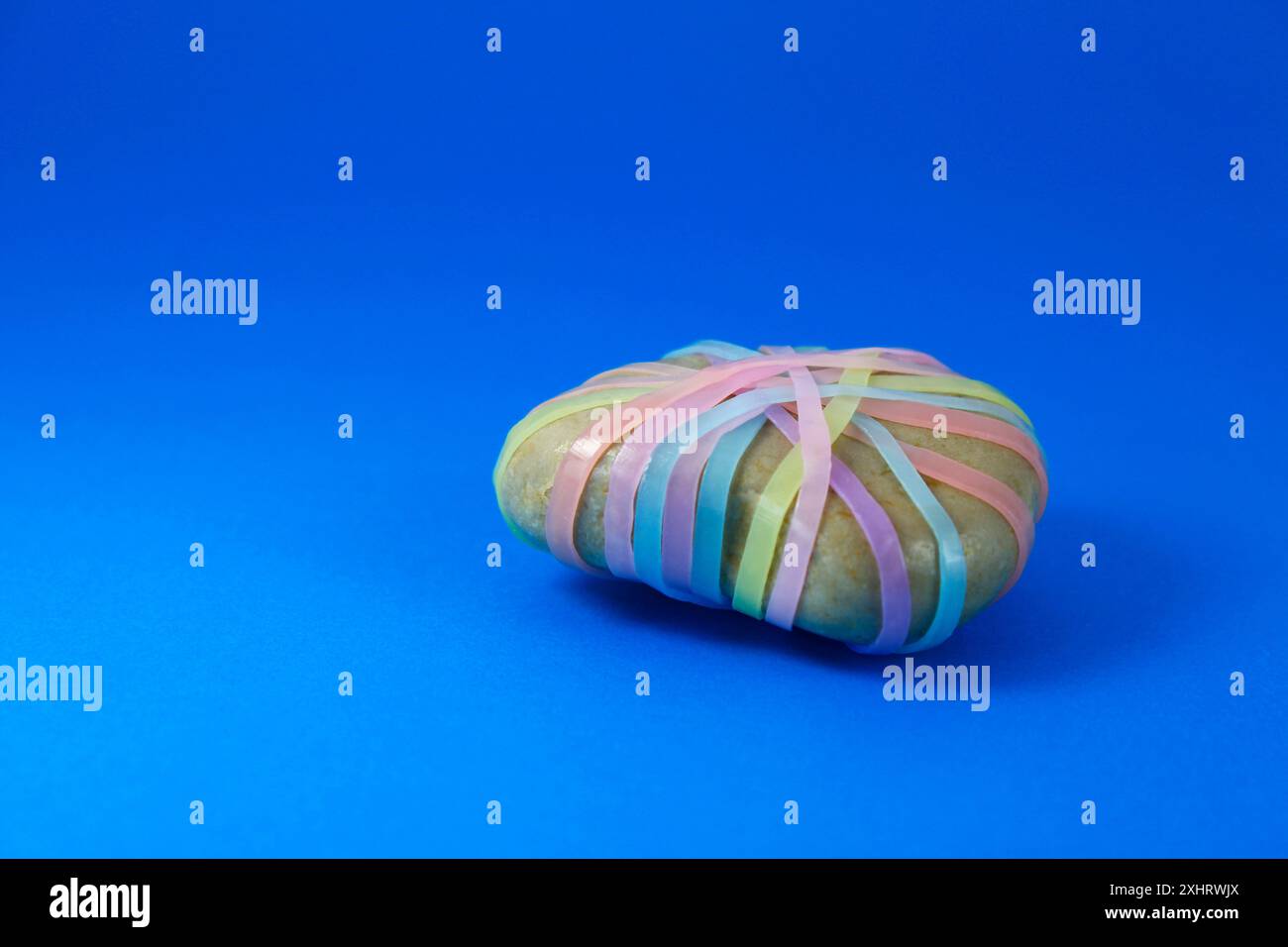 Stein mit bunten Gummibändern gebunden Stockfoto
