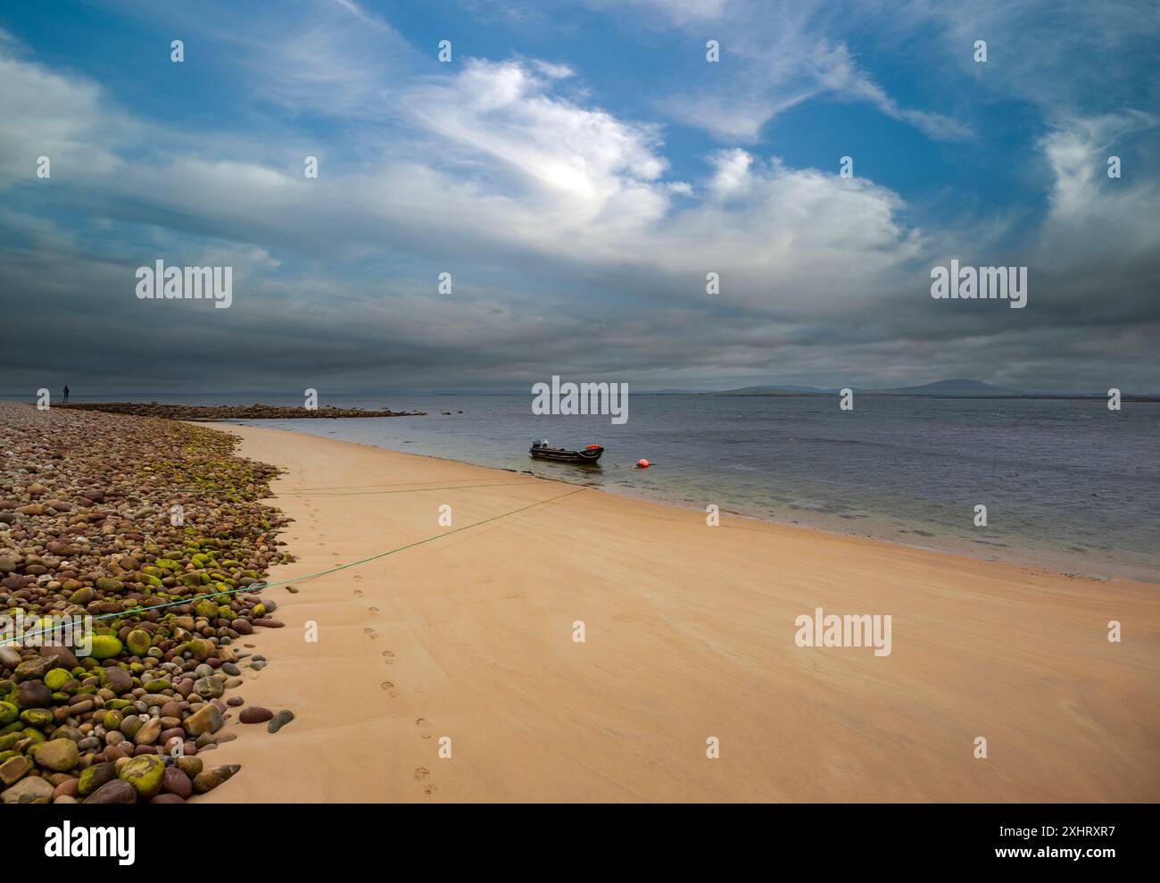 Ein einsamer Currach lag vor einem verlassenen Dooniver Strand, gegenüber der Insel Inishbiggle, vor der nordöstlichen Seite von Achill Island, County Mayo, Irland. Stockfoto