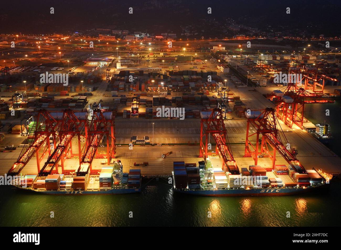 LIANYUNGANG, CHINA - 15. JULI 2024 - Frachtschiffe entladen Container am Containerterminal des Hafens Lianyungang, Provinz Jiangsu im Osten Chinas, Juli Stockfoto