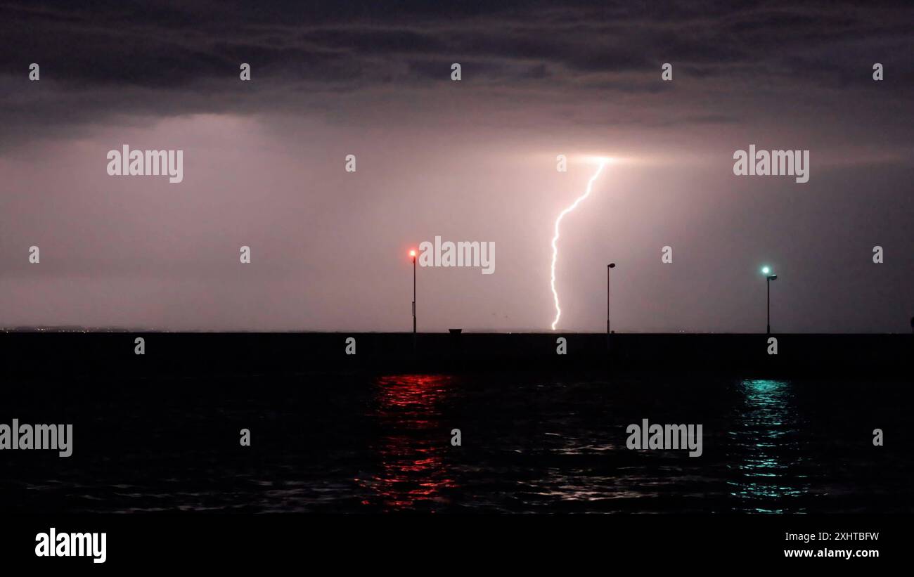 Deutschland kommt nicht zur Ruhe. Abermals sind schwere Gewitter und Unwetter über Süddeutschland hinweggezogen. Am Abend formierte sich am Bodensee eine massive Gewitterfront und fegte einmal komplett über Baden-Württemberg und Südbayern hinweg. Gegen 21 Uhr leuchteten die Sturmwarnleuchten am Bodensee, warnen für einen aufziehenden Unwetter. Dennoch ließ sich eine Schwimmerin von der nahenden Gefahr nicht abhalten. Im Zeitraffer und intensive Blitze sah man eindrucksvoll die Macht der heranziehenden Unwetter. Bei Leutkirch im Allgäu entluden sich anschließend die aufziehenden Unwetter. Schwe Stockfoto