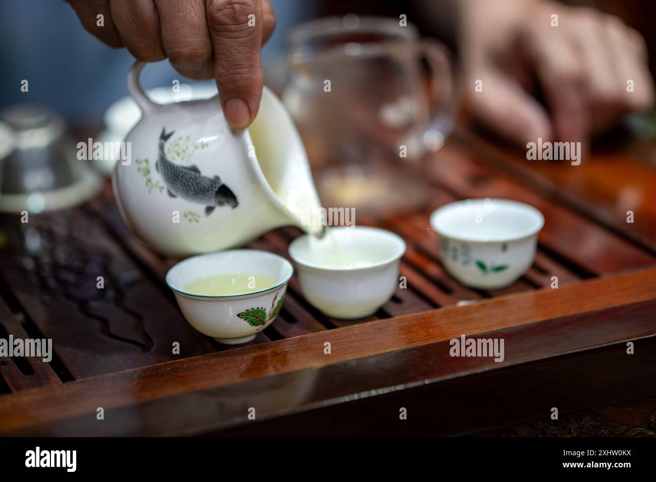 Einige Zeremonie-Sets liegen auf dem Tisch. Der Teetisch steht auf dem Tisch. Teesets wie Teekannen und Tassen befinden sich in Holztabletts. Prozess des Teegießens während einer Stockfoto