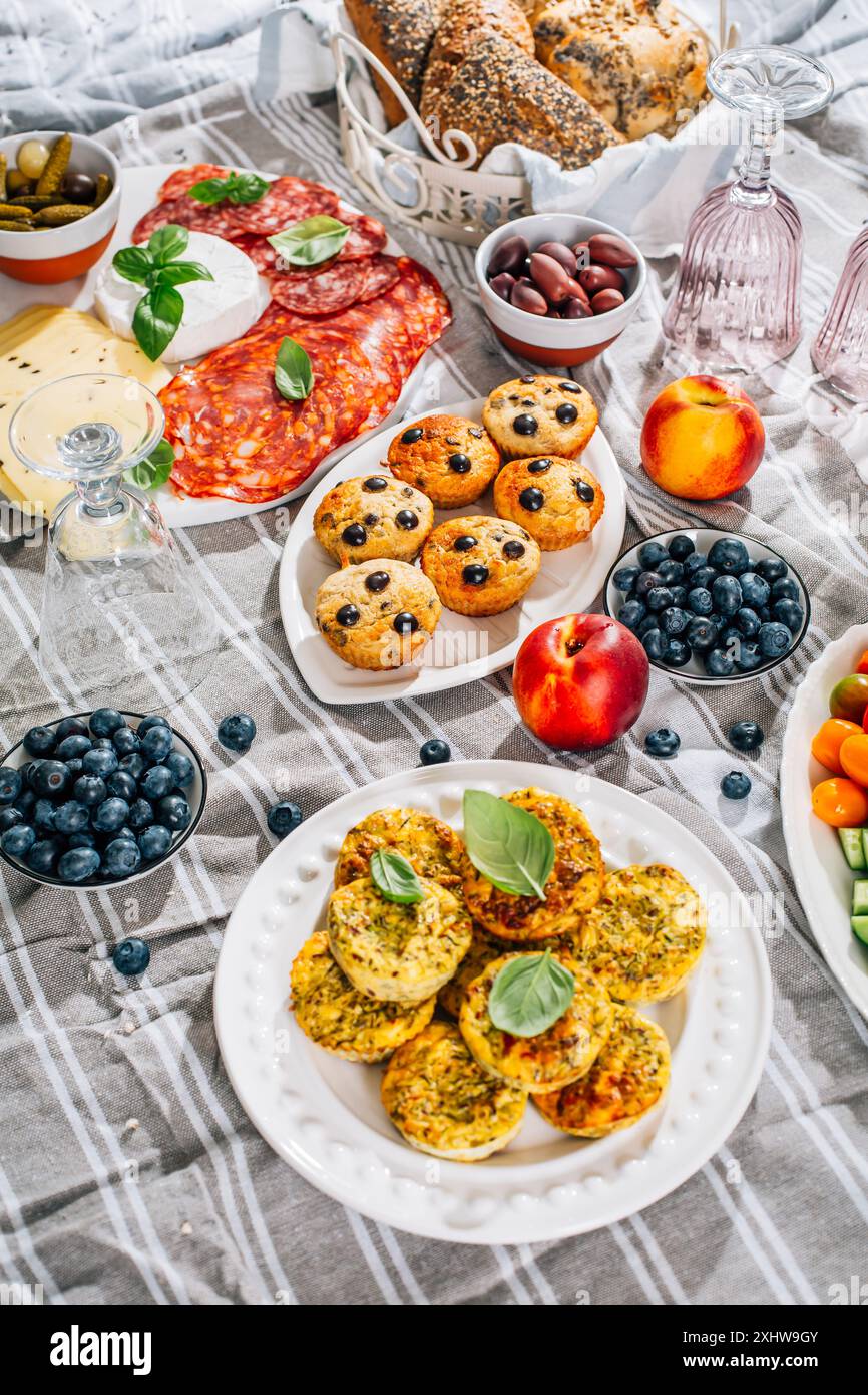 Picknick, Vorspeisen und Käse- und Fleischplatte mit süßen und herzhaften Muffins und Obst Stockfoto