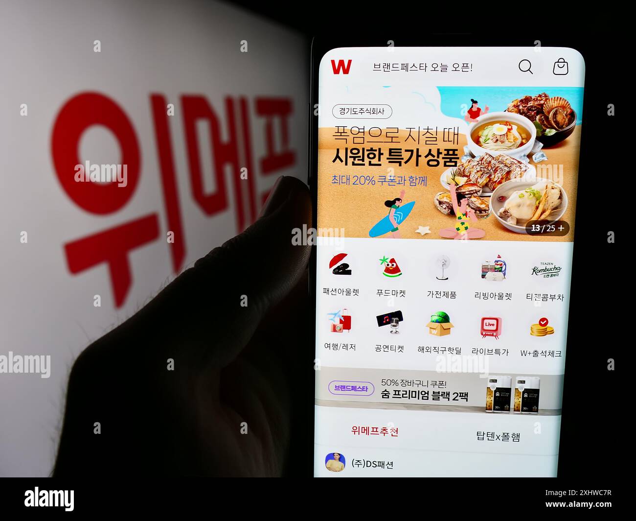 Person, die ein Mobiltelefon mit der Webseite des südkoreanischen E-Commerce-Unternehmens Wemakeprice vor dem Geschäftslogo hält. Konzentrieren Sie sich auf die Mitte des Telefondisplays. Stockfoto