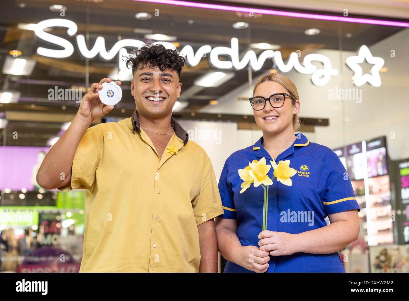 Die Schauspielerin Karim Zeroual und Marie Curie Senior Nurse Sophie Graham beim Start der Gelb-Pfennige-Spendeninitiative in Superdrug, Manchester, drängten die Käufer, ihre Einkäufe um 20 Pent aufzustocken, um für die wichtige Arbeit der führenden britischen End-of-Life-Wohltätigkeitsorganisation zu spenden. Ausgabedatum: Dienstag, 16. Juli 2024. Stockfoto