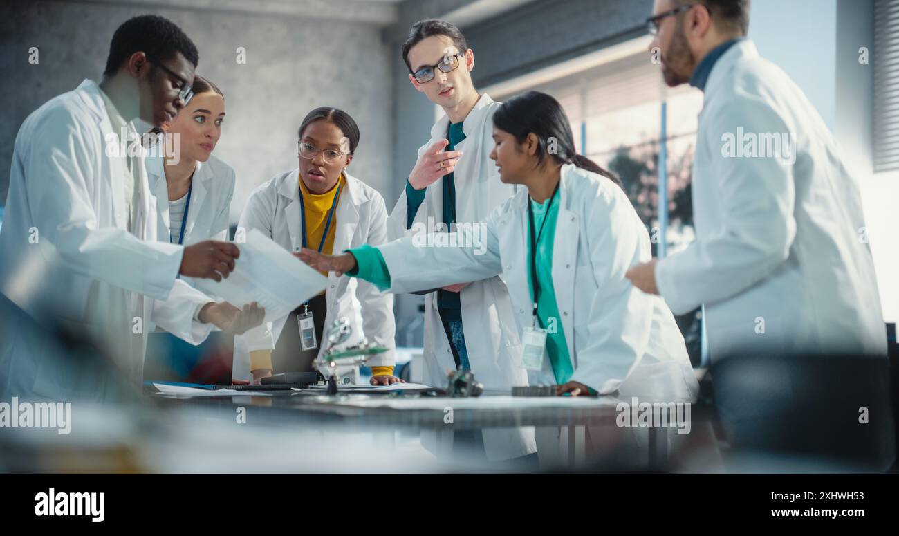 Internationale Fertigungsleiter diskutieren über Daten, die in der Produktanalyse mit Laptop- und Tablet-Computern gesammelt wurden. Gruppe von Young Professional Specialists, die Brainstorming durchführen und Probleme lösen Stockfoto