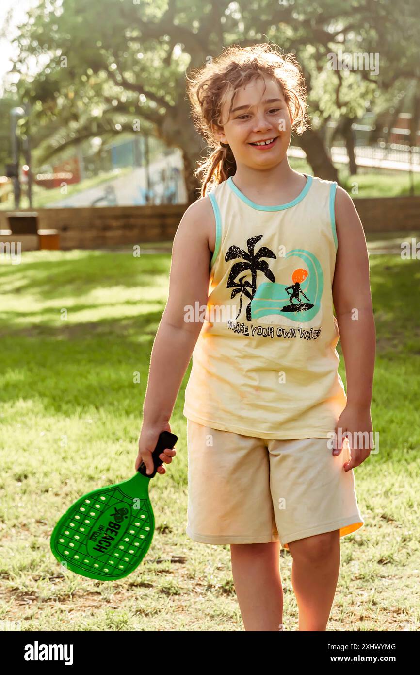 Kinder, die an einem sonnigen Feiertag Spaß beim Paddelall haben, genießen Outdoor-Aktivitäten im Park. Stockfoto