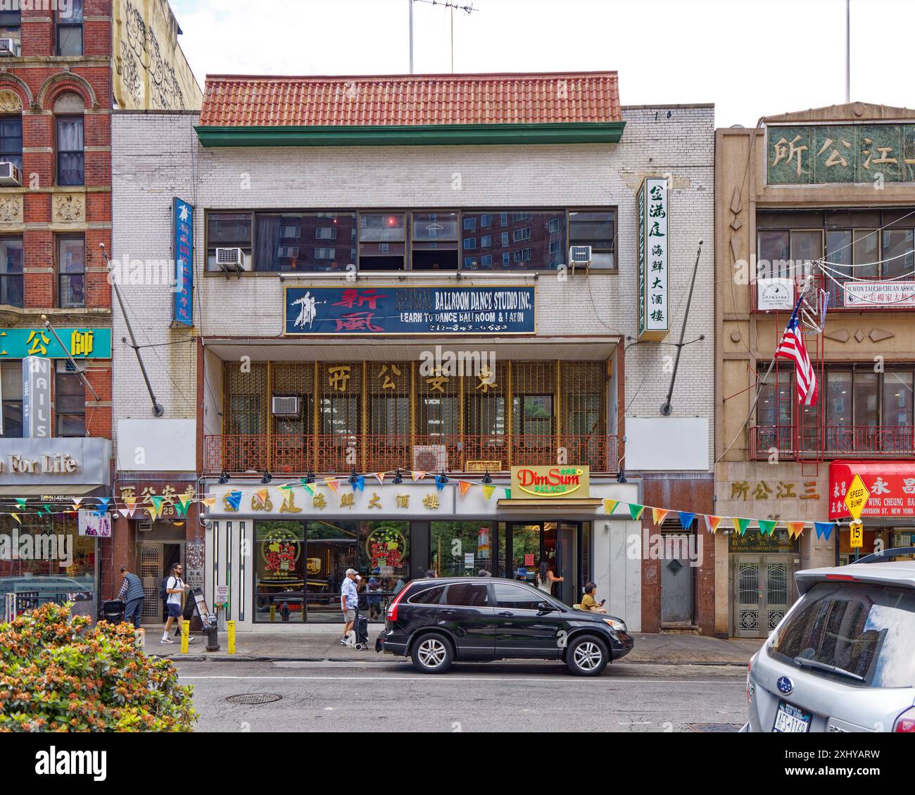 NYC Chinatown: Privater Club, Tanzstudio und Restaurant in einem weißen Backsteingebäude, das von einem roten Fliesendach im Pagodenstil bedeckt ist. Stockfoto