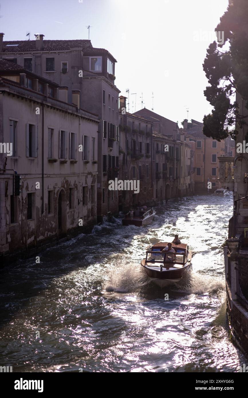 Motorboot im Kanal in Venedig Italien bei Sonnenuntergang Stockfoto