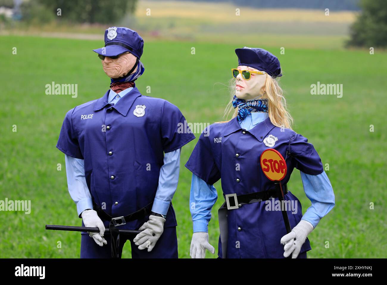 Humorvolles Stillleben mit männlichen und weiblichen Polizeifiguren, die eine Sonnenbrille tragen und einen Stoppstab und ein Stoppschild halten. Salo, Finnland. Juli 2024. Stockfoto