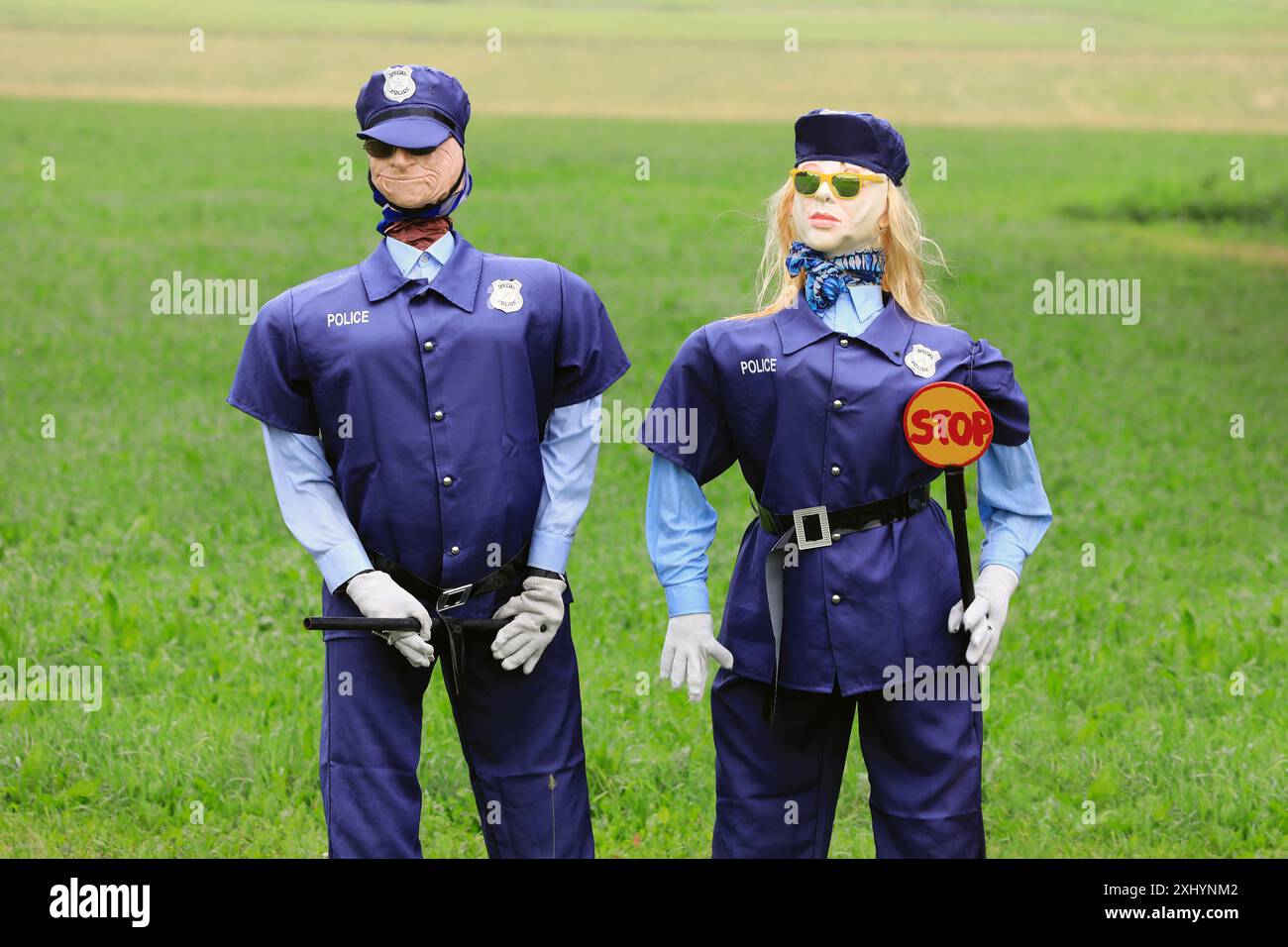 Humorvolle Abmachung mit männlichen und weiblichen Polizeifiguren, die eine Sonnenbrille tragen und einen Schlagstock und ein Stoppschild halten. Salo, Finnland. Juli 2024. Stockfoto