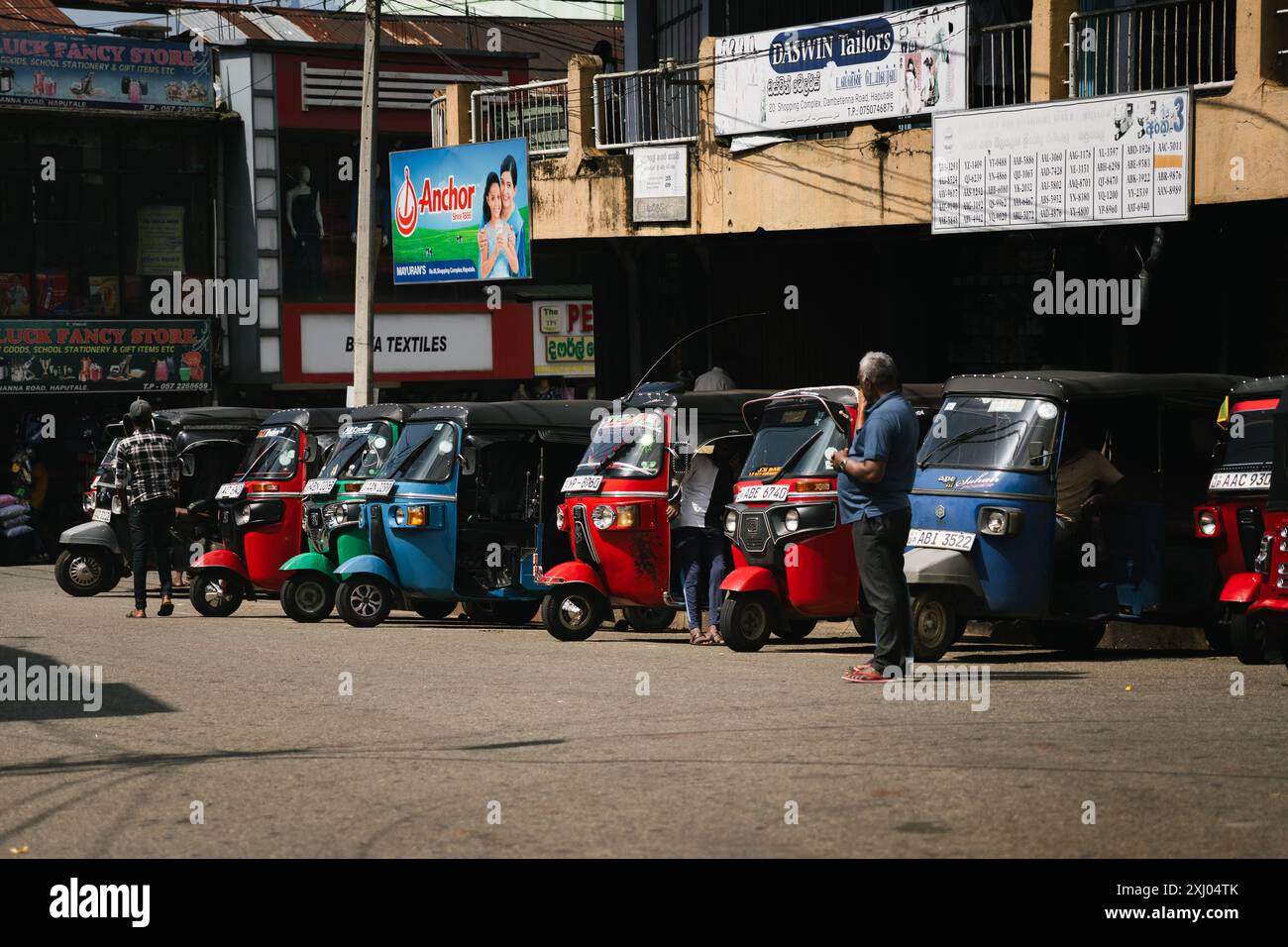 Reihe farbenfroher Auto-Rikschas, die vor einem Marktgebiet in Haputale, Sri Lanka, geparkt sind. Stockfoto