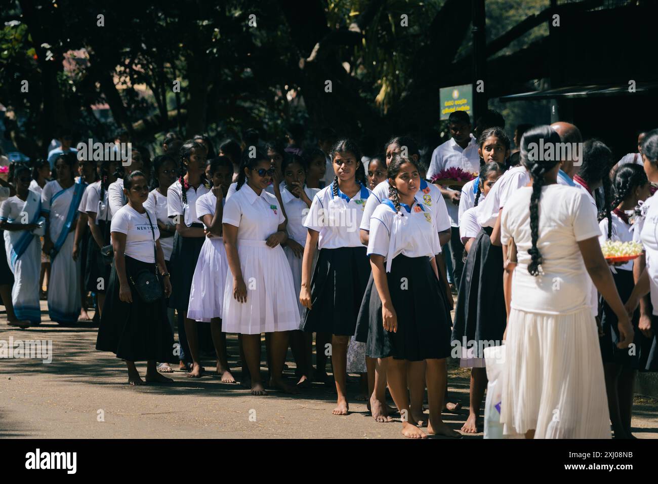 Eine Gruppe junger Frauen in weißen Uniformen nimmt an einer Outdoor-Veranstaltung in Kandy, Sri Lanka, Teil Stockfoto