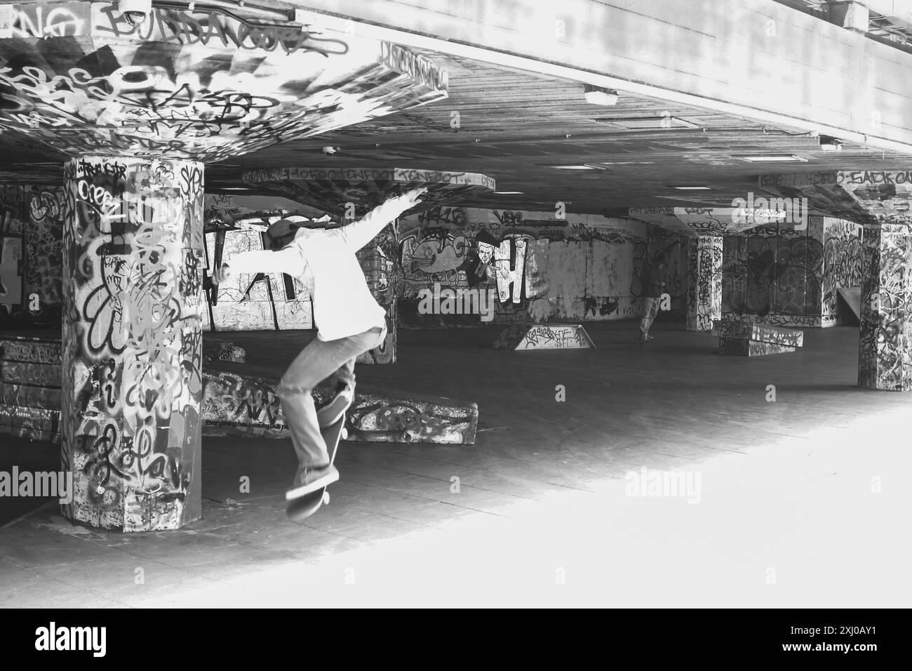 Skateboarder, der Tricks auf seinem Skateboard zieht ( Black and White ), Southbank Skatepark Undercroft Skate Space, London, England Stockfoto