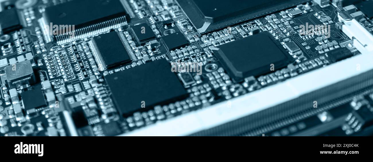 Detaillierte Nahaufnahme einer elektronischen Leiterplatte mit Mikrochips, Widerständen und anderen Komponenten, die moderne Technologie und Hardware repräsentieren. Stockfoto