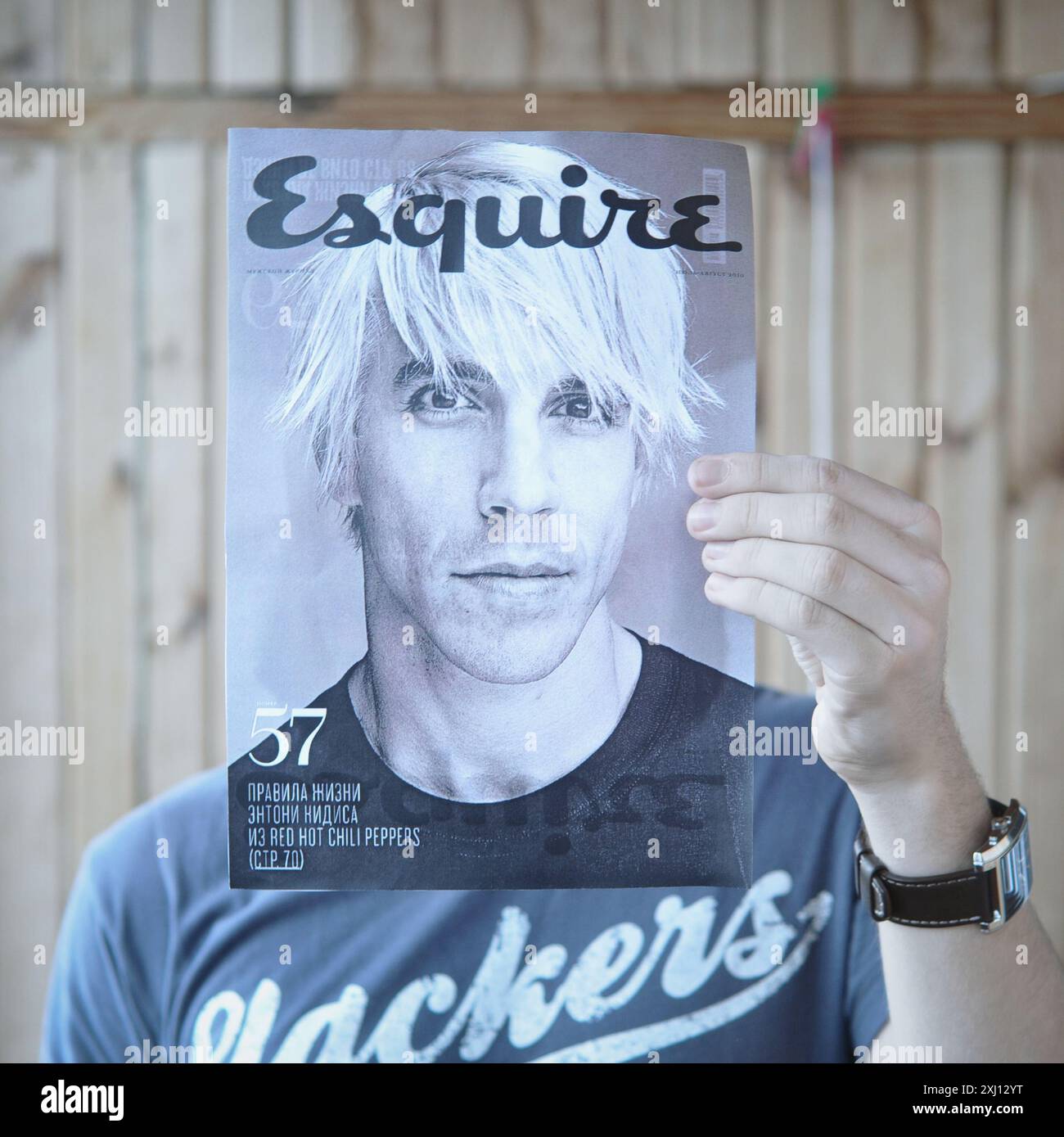 Falsche Identität: Anthony Kiedis. Eine Person, die ein Magazin mit einem Porträt eines berühmten Sängers hält und es als Maske benutzt. Kommunikation mit einem Fremden. Stockfoto