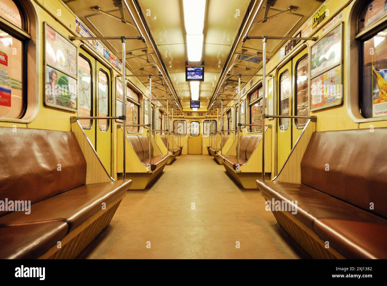 Leere U-Bahn. Warmes Bild eines leeren Eisenbahnwagens, symmetrische abnehmende perspektivische Ansicht des Innenraums der U-Bahn. Stockfoto