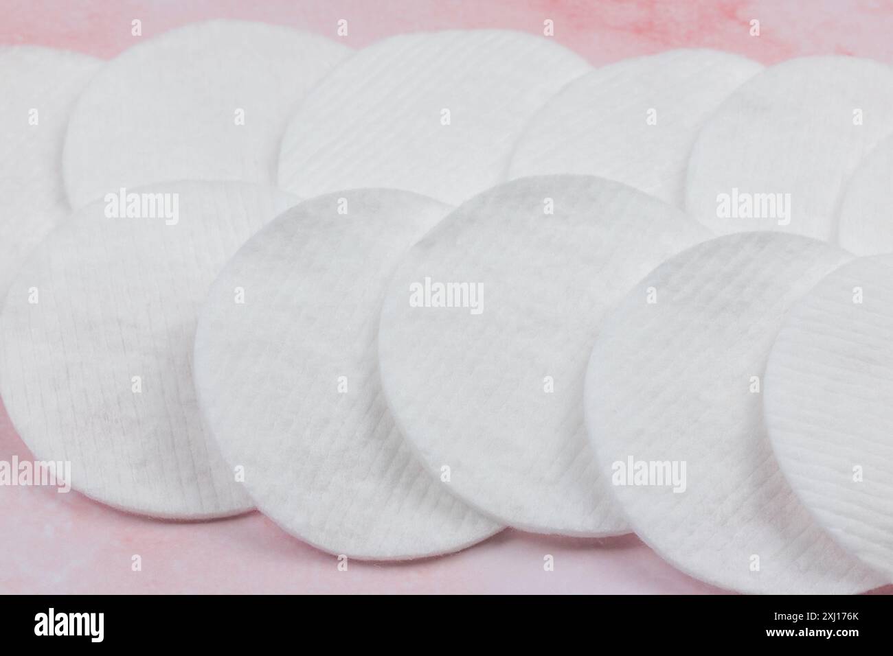 Baumwoll-Make-up-Entferner-Pads auf rosa Hintergrund Stockfoto